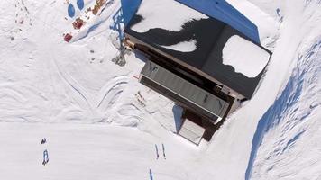 vista aérea superior turista con instructores aprende a hacer snowboard en pendiente por teleférico teleférico video