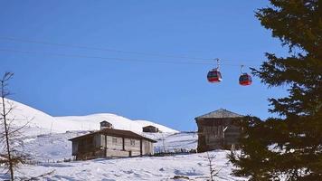 Teleférico en la estación de esquí de Goderdzi con antiguas casas de madera en las montañas de Adjara en invierno video