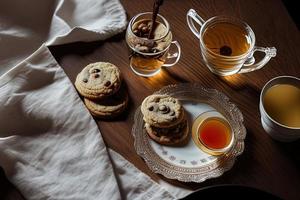 fotografía de un plato de galletas y un vaso de té sobre una mesa con un paño y una servilleta encima foto