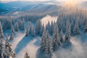 aerial landscape photo shot of a mountain from above, mist and snow