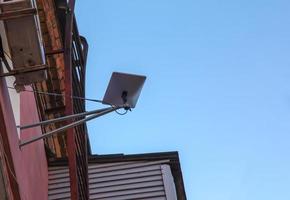 Starlink satellite dish, an internet constellation operated by SpaceX, is installed on the wall of an apartment building. photo