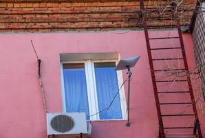 Starlink satellite dish, an internet constellation operated by SpaceX, is installed on the wall of an apartment building. photo