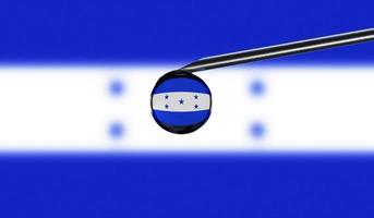 Vaccine syringe with drop on needle against national flag of Honduras background. Medical concept vaccination. Coronavirus Sars-Cov-2 pandemic protection. National safety idea. photo