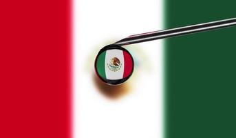 Vaccine syringe with drop on needle against national flag of Mexico background. Medical concept vaccination. Coronavirus Sars-Cov-2 pandemic protection. National safety idea. photo