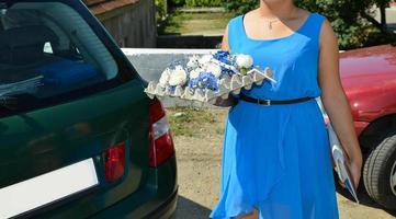 bridesmade dressed in blue on the street is holding wedding flowers in her hand photo