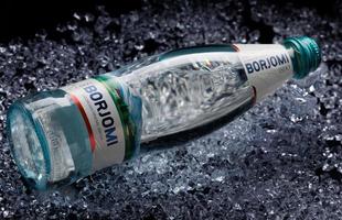 KRASNOYARSK, RUSSIA - OCTOBER 21, 2022 A bottle of Borjomi mineral water lies on crushed ice. photo