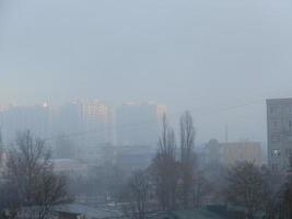 Morning winter fog hangs over the city photo