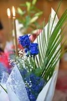 blue roses flower bouquet with candles in the background photo
