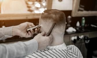 manos de peluquero haciendo corte de pelo foto