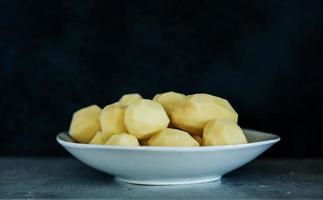 Peeled potatoes in plate photo