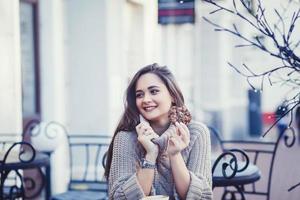 woman in autumn outfit chilling in cozy cafe photo