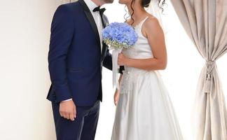 bride and groom together holding a blue flower bouquet photo