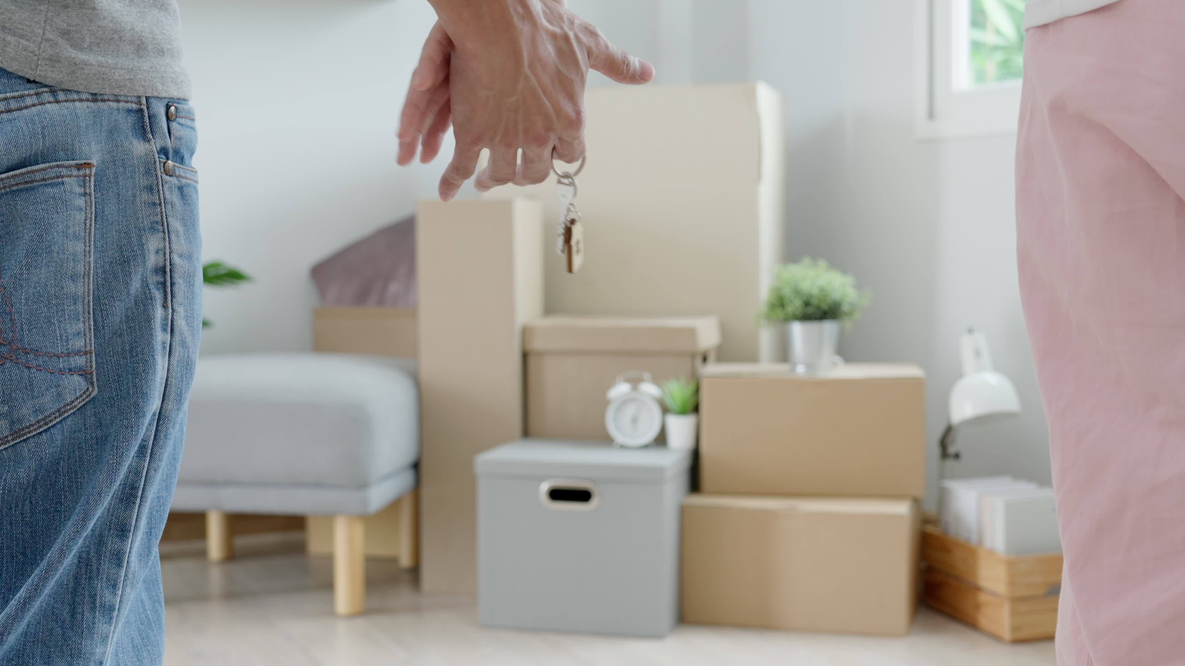 Moving house, relocation. Couple hold key house keychain in new