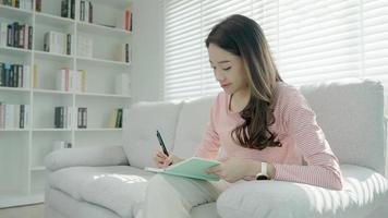 inspiration, écrivain, écriture, création, loisirs pour imaginer, belle jeune femme asiatique séduisante écrivant des idées sur un cahier, liste de choses à faire, bon travail de réflexion, journaliste, élégant, image de rêve, détente video