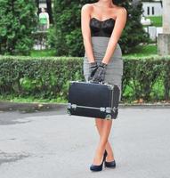 beautiful brunette model is having a vintage photo shooting. The woman is wearing a short skirt and blue high heels