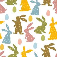 A pattern of Easter bunnies made of polka dot fabric and colored eggs. Rabbit toys for children. Rabbit or hare, a spring festive animal for Easter. Cartoon simple vector character made of fabric.
