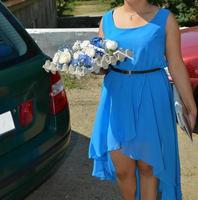 bridesmade dressed in blue on the street is holding wedding flowers in her hand photo