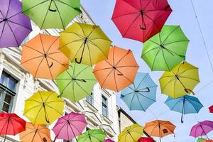 paraguas de colores colgado en las calles de la ciudad foto