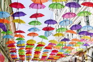 paraguas de colores colgado en las calles de la ciudad foto