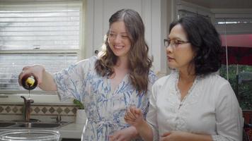 mujer enseñando a una mujer más joven a cocinar video