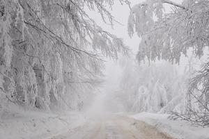 Winter snowy road in mountainous region after heavy snowfall in Romania photo