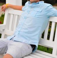 portrait of a young man relaxing on the bench in the park photo