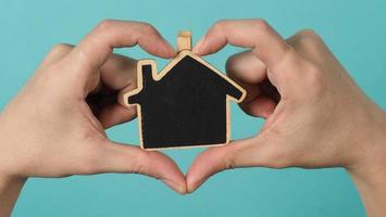 Small wood house in hands represent concepts such as home care family love photo