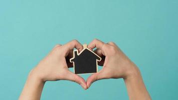 Small wood house in hands represent concepts such as home care family love photo
