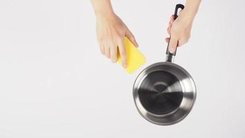 Pot cleaning Man hand on white background cleaning the non stick pot photo