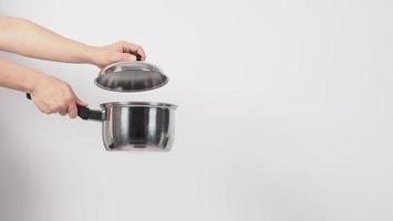 Pot cleaning Man hand on white background cleaning the non stick pot photo