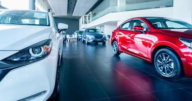White car parked in luxury showroom. Car dealership office. New car parked in modern showroom. Car for sale and rent business concept. Automobile leasing and insurance concept. Electric vehicle. photo