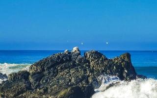 Beautiful rocks cliffs surfer waves at beach Puerto Escondido Mexico. photo