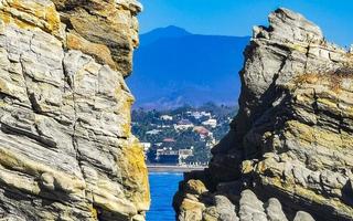 Beautiful rocks cliffs surfer waves at beach Puerto Escondido Mexico. photo