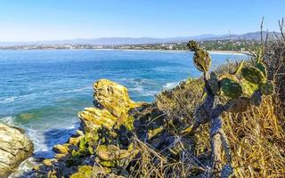 Beautiful rocks cliffs surfer waves at beach Puerto Escondido Mexico. photo