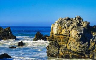 hermosas rocas acantilados olas surfistas en la playa puerto escondido mexico. foto