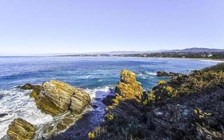 Beautiful rocks cliffs surfer waves at beach Puerto Escondido Mexico. photo