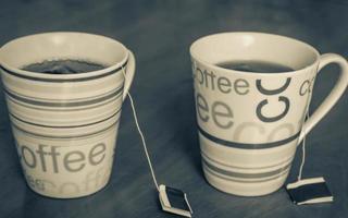 Two coffee cup with colored text filled with tea. photo