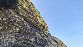 Beautiful rocks cliffs surfer waves at beach Puerto Escondido Mexico. photo