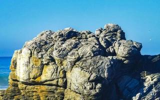 hermosas rocas acantilados olas surfistas en la playa puerto escondido mexico. foto