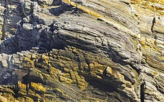 Beautiful rock cliff stone boulder texture pattern beach in Mexico. photo