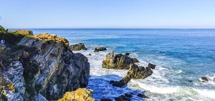 Beautiful rocks cliffs surfer waves at beach Puerto Escondido Mexico. photo