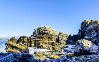 Beautiful rocks cliffs surfer waves at beach Puerto Escondido Mexico. photo