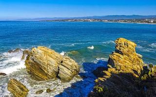 hermosas rocas acantilados olas surfistas en la playa puerto escondido mexico. foto