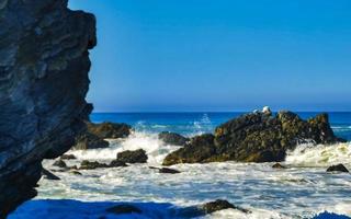 Beautiful rocks cliffs surfer waves at beach Puerto Escondido Mexico. photo