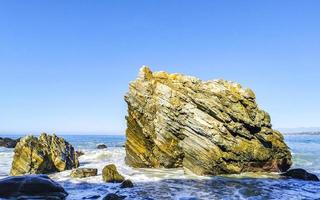 Beautiful rocks cliffs surfer waves at beach Puerto Escondido Mexico. photo