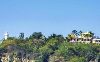 White small lighthouse on cliff in Puerto Escondido Mexico. photo