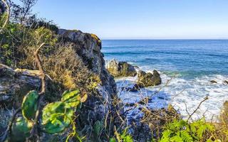 Beautiful rocks cliffs surfer waves at beach Puerto Escondido Mexico. photo