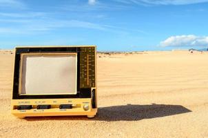 Old television in the sand photo