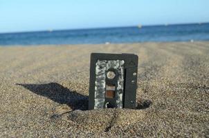 Old casette tape in the sand photo