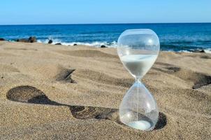 Hourglass on the sand beach photo